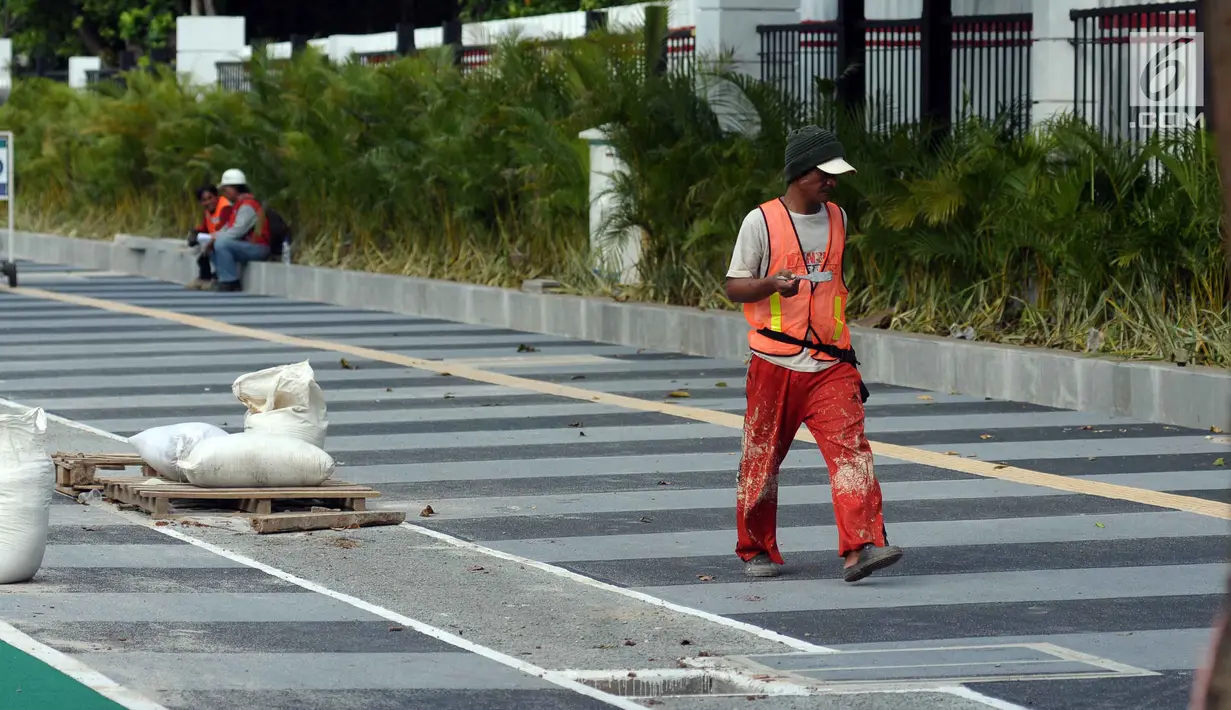Pekerja melakukan pengerjaan tahap akhir renovasi trotoar di sekitar Jalan Gerbang Pemuda, Senayan, Jakarta, Selasa (29/5). Penataan trotoar menjadi prioritasmengingat Asian Games tinggal beberapa bulan ke depan. (Liputan6.com/Helmi Fithriansyah)