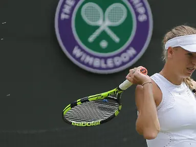 Petenis Denmark, Caroline Wozniacki diserang semut terbang ketika melawan petenis Rusia, Ekaterina Makarova pada babak kedua Wimbledon 2018 di All England Club, London, Rabu (4/7). Wozniacki tersingkir dengan skor 4-6, 6-1, 5-7. (AFP/Daniel LEAL-OLIVAS)