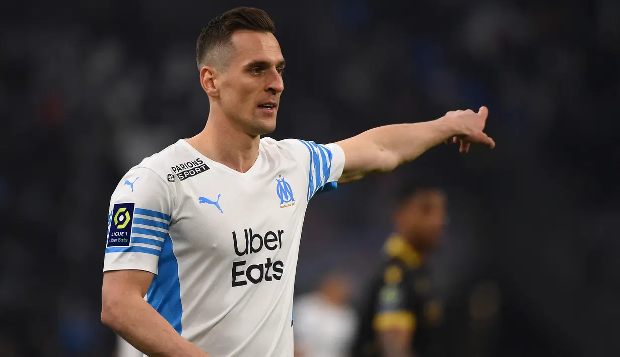 Arkadiusz Milik. Striker berusia 28 tahun yang sejak tengah musim 2020/2021 dipinjamkan Napoli ke Olympique Marseille ini baru saja dipermanenkan pada bursa transfer musim panas 2022/2023. Olympique Marseille harus mengeluarkan biaya 8 juta euro untuk mempermanenkannya dengan durasi kontrak hingga Juni 2025. Selama 1,5 musim membela Marseille, ia total tampil dalam 53 laga di semua ajang dengan torehan 30 gol dan 3 assist. Sementara bersama Timnas Polandia ia telah mengoleksi 62 caps dengan torehan 16 gol dan 16 assist sejak melakukan debut pada 12 Oktober 2012. (AFP/Sylvain Thomas)
