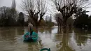 Marcel Leclercq menggunakan perahu di jalan yang banjir di pulau Vaux, sebelah barat Paris, (30/1). Sungai Seine yang meluap akibat hujan deras dalam 50 tahun telah menelan dermaga di Paris, Prancis. (AP Photo / Thibault Camus)