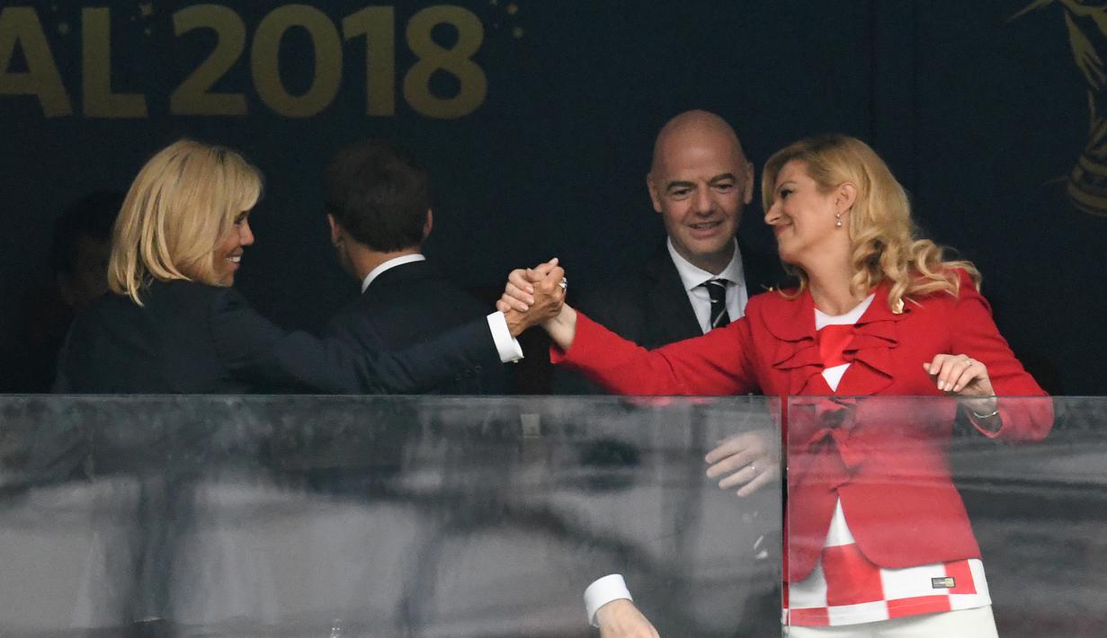 Kolinda Grabar-Kitarovic (kanan) menyapa istri Presiden Prancis, Brigitte Macron pada final Piala Dunia 2018 di Luzhniki Stadium, Moskow, Rusia, (15/7/2018). Meski Kroasia kalah Kolinda Grabar-Kitarovic tetap tersenyum manis. (AFP/Christophe Simon)