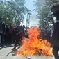 Foto: Mahasiswa membakar ban bekas di jalan El Tari Kupang saat menggelar aksi demontrasi menolak UU cipta kerja (Liputan6.com/Ola Keda)