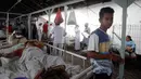 Pasien dievakuasi keluar rumah sakit di Bali menyusul gempa Lombok, Senin (6/8). Gempa 7 pada skala richter yang berpusat di Lombok, menyebabkan kerusakan bangunan di berbagai lokasi di Bali dan mengakibatkan sejumlah warga terluka. (AP/Firdia Lisnawati)