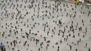 Selain memancing di atas es, pengunjung dapat mencoba menangkap ikan dengan tangan kosong, meluncur dengan kereta salju (sledding), bobsled, hingga mengunjungi alun-alun patung es dalam ruangan terbesar di dunia. Tampak dalam foto, orang-orang memancing melalui lubang-lubang di sungai yang membeku selama festival tahunan memancing di atas es, Hwacheon, Korea Selatan, pada Sabtu 10 Januari 2026. (Shin Yong-ju/AFP)