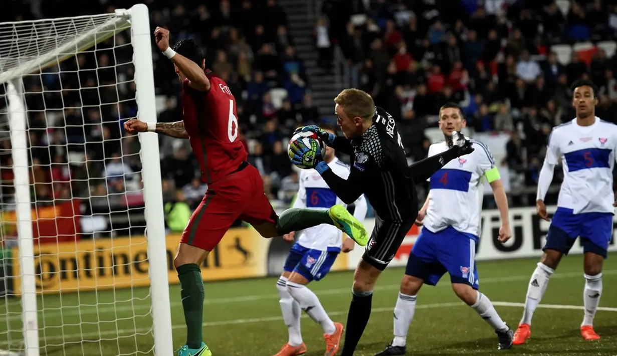Kiper Kepulauan Faroe, Gunnar Nielson, mengamankan gawangnya dari serangan pemain Portugal pada laga Grup B Kualifikasi Piala Dunia 2018 zona Eropa di Torsvollur Stadium, Selasa (11/10/2016) dini hari WIB. (AFP/Francisco Leong)