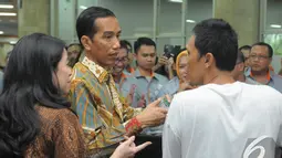 Presiden Jokowi berdialog dengan seorang warga yang mengantre untuk mendapatkan Kartu Indonesia Sehat di Kantor Pos Pasar Baru, Jakarta, Senin (3/11/2014). (Liputan6.com/Herman Zakharia)