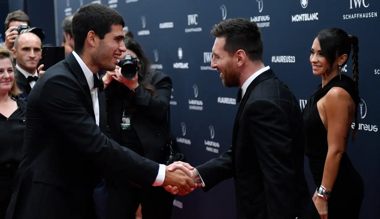 Lionel Messi (kanan) bersalaman dengan Carlos Alcaraz, petenis Spanyol peraih penghargaan kategori breaktrough award pada acara seremoni Laureus Awards 2023 di Paris, Prancis, Selasa (9/5/2023) dini hari WIB. Lionel Messi sebelumnya juga pernah meraih penghargaan Laureus Awards pada tahun 2020 untuk kategori individu bersanding dengan pebalap F-1 asal Inggris, Lewis Hamilton. (AFP/Julien De Rosa)