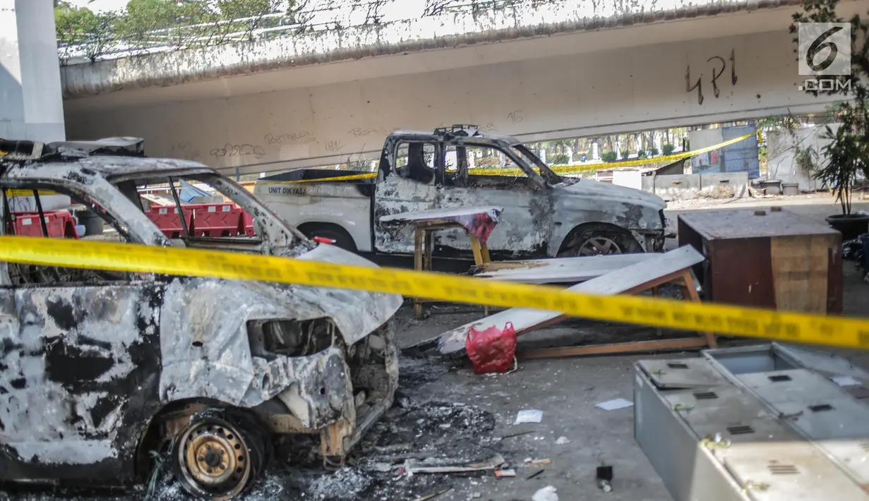Dua unit mobil polisi usai dibakar massa aksi  unjuk rasa di pos polisi fly over simpang Tomang, Jakarta, Kamis (26/9/2019). Selain menghanguskan pos polisi, api juga membakar belasan sepeda motor dan dua unit mobil polisi yang tengah terparkir di area pos pol Tomang. (Liputan6.com/Faizal Fanani)