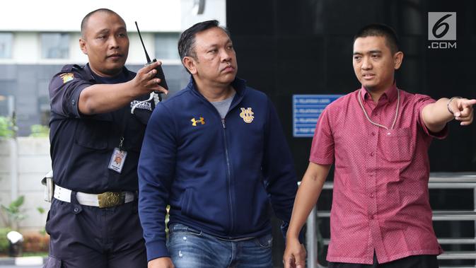 Bupati Pakpak Bharat Sumatera Utara, Remigo Yolanda Berutu (tengah) digiring petugas saat tiba di Gedung KPK, Jakarta, Minggu (18/11). Remigo terkena OTT terkait dugaan penerimaan suap proyek di Dinas PUPR. (Liputan6.com/Helmi Fithriansyah)