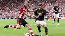 Striker Southampton, James Ward-Prowse, berebut bola dengan gelandang Manchester United, Daniel James, pada laga Premier League di Stadion St Mary's, Southampton, Sabtu (31/8). Kedua klub bermain imbang 1-1. (AP/Mark Kerton)