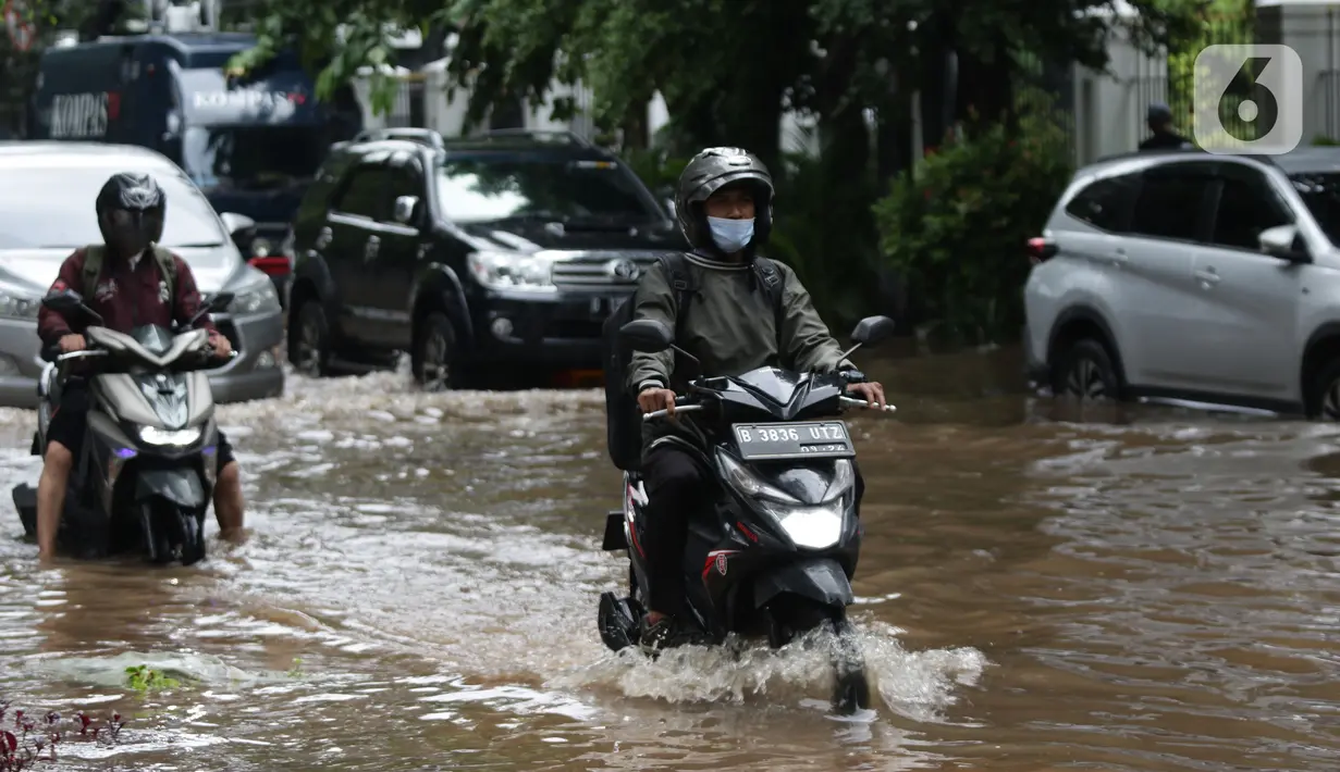 Pengendara sepeda motor menerobos sebagian Jalan Bungur Besar Raya yang tergenang air, Jakarta, Selasa (18/1/2022). Genangan air membuat arus lalu lintas di sekitar depan PN Jakarta Pusat menjadi terganggu dan tersendat. (Liputan6.com/Helmi Fithriansyah)