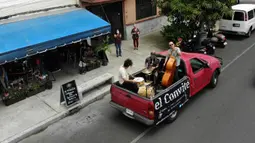 Band Maroto Jazz Trio yang terdiri dari Diego Maroto pada Saxophone, Jorge Molina pada double bass, dan Edy Vega pada drum tampil dari atas sebuah van melewati kawasan Mexico City, Meksiko, 29 Agustus 2020. Penampilan mereka dilakukan di tengah pandemi virus corona COVID-19. (RODRIGO ARANGUA/AFP)