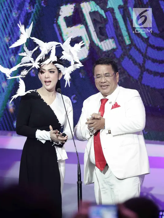 Penyanyi Syahrini saat membacakan nominasi bersama pengacara Hotman Paris dalam acara SCTV Music Awards 2018 di Studio 6 Emtek, Jakarta, Jumat (27/4). Selain tampil menyanyi, Syahrini juga ikut membacakan nominasi. (Liputan6.com/Faizal Fanani)