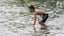 Seorang anak bermain di genangan air akibat banjir rob di kawasan pintu masuk Pelabuhan Nizam Zachman, Muara Baru, Jakarta, Jumat (5/6/2020). Banjir rob di Pelabuhan Muara Baru tersebut terjadi akibat cuaca ekstrem serta pasang air laut. (Liputan6.com/Helmi Fithriansyah)