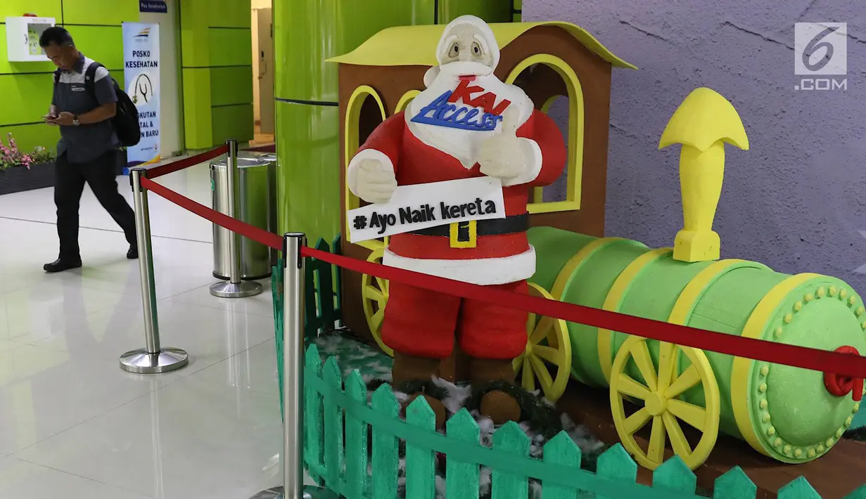 Penumpang melintas di sekitar dekorasi bertema Natal dan Tahun Baru di Stasiun Gambir, Jakarta, Jumat (21/12). Dekorasi dibuat untuk memercantik suasana Stasiun Gambir dalam rangka menyambut Hari Natal dan Tahun Baru 2019. (Liputan6.com/Immanuel Antonius)
