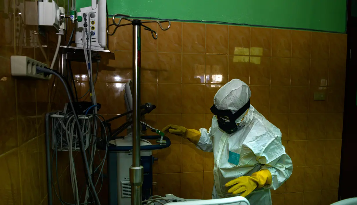 Petugas medis dengan pakaian pelindung menyiapkan ruang isolasi di sebuah rumah sakit di Banda Aceh, Selasa (3/3/2020). Di Aceh, dua rumah sakit menjadi rujukan pasien virus Corona, yakni Rumah Sakit Umum dr Zainoel Abidin (RSUZA) Banda Aceh dan RSUD Cut Meutia, Aceh Utara. (CHAIDEER MAHYUDDIN/AFP)
