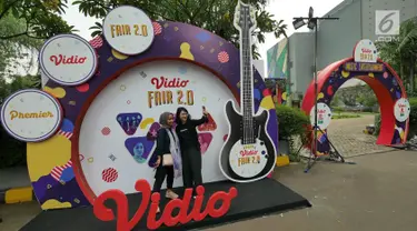 Pengunjung berfoto di booth Vidio Fair 2.0 yang digelar di Mall Gandaria City, Jakarta, Sabtu (3/11). Acara Vidio Fair 2.0 diramaikan dengan berbagai macam kegiatan yang dapat dinikmati oleh pengunjung yang hadir. (Liputan6.com/Herman Zakharia)