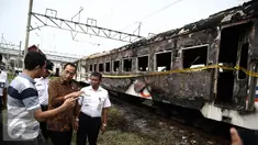Menhub Budi Karya menyimak keterangan warga saat meninjau lokasi terbakarnya dua gerbong kereta Kerta Jaya kelas Ekonomi di dekat Stasiun Tanjung Priok, Jakarta, Kamis (25/8). (Liputan6.com/Faizal Fanani)