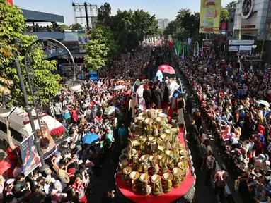 Ribuan warga berkumpul saat kendaraan hias yang ditumpangi Presiden Joko Widodo (Jokowi) dan Ibu Negara, Iriana Joko Widodo selama Karnaval Kemerdekaan Pesona Parahyangan 2017 melintas di pusat Kota Bandung, Sabtu (26/8). (Liputan6.com/Johan Tallo)