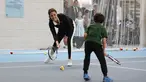 Kate Middleton berlatih bersama seorang anak saat mengunjungi Lawn Tennis Association di Pusat Tenis Nasional, London, Senin (31/10). Kate yang tengah hamil anak ketiga itu tampak mengenakan pakaian serba sporty. (Daniel LEAL-OLIVAS/POOL/AFP)