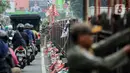 Sejumlah bendera partai politik yang ditempelkan pada pagar pembatas jalan ditertibkan oleh petugas Satpol PP di Jalan Raya Jakarta - Bogor. (Liputan6.com/Faizal Fanani)