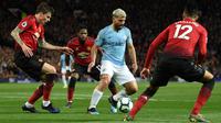 Striker Manchester City Sergio Aguero berebut bola dengan  pemain Manchester United, Victor Lindelof, Fred dan Chris Smalling dalam laga lanjutan Liga Inggris di Stadion Old Trafford, Rabu (24/4). Man City berhasil membungkam rival sekota Manchester United dua gol tanpa balas. (Oli SCARFF / AFP)