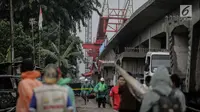 Sejumlah petugas dan pekerja memeriksa kondisi crane pengerjaan proyek double-double track kereta api di Jatinegara yang ambruk, Jakarta, Minggu (4/2). (Liputan6.com/Faizal Fanani)