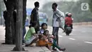 Penyandang Masalah Kesejahteraan Sosial (PMKS) menunggu warga memberikan sedekah di pinggir jalan, Jakarta, Rabu (13/5/2020). Sejumlah PMKS menantikan sedekah berupa uang, makanan, hingga sembako dari pengendara yang melintas. (merdeka.com/Iqbal S. Nugroho)