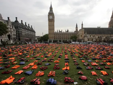 Jaket pelampung dipajang seperti sebuah pemakaman umum di dekat Gedung Parlemen London, Senin (19/9).  Sebanyak 2.500 jaket pelampung yang usang ini pernah dipakai para pengungsi yang menyebrang dari Turki ke Pulau Chios, Yunani. (Daniel Leal-Olivas/AFP)