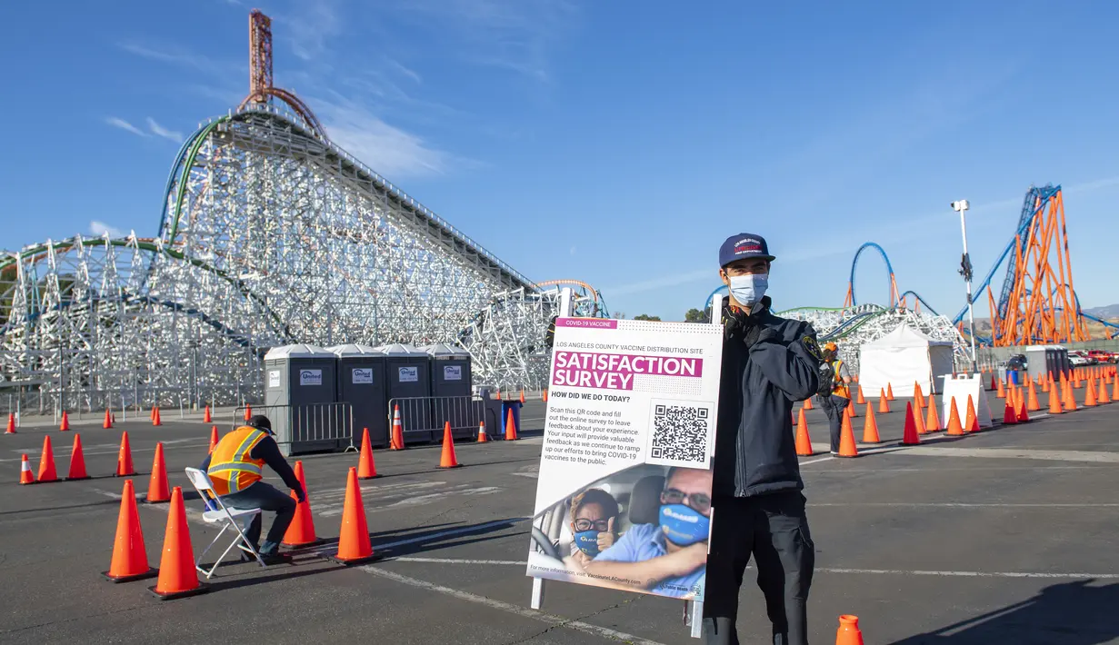 Seorang petugas kesehatan menampilkan papan di pusat vaksinasi Covid-19 skala besar yang didirikan di Six Flags Magic Mountain di Valencia, California, Selasa (2/2/2021). Situs ini di salah satu dari lima situs vaksin corona utama yang dioperasikan oleh Los Angeles County. (VALERIE MACON/AFP)