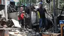 Aksi balas dendam massa terjadi dengan melakukan pembakaran tenda pedagang dan kendaraan. Tampak dalam foto, pemilik kios membersihkan puing-puing bangunan usai kebakaran yang melanda deretan kios di kawasan Kalibata, Jakarta Selatan, pada Jumat (12/12/2025). (merdeka.com/magang/Rendi Saputra)
