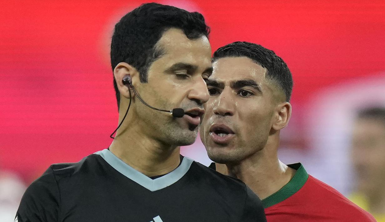 Achraf Hakimi tampak menjadi pemain Maroko yang paling kecewa dengan Abdulrahman Al Jassim (kiri). Bek asal Paris Saint-Germain itu terus melemparkan kata-kata kepada pengadil lapangan asal Qatar. (AP Photo/Francisco Seco)