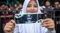 Seorang suporter menunjukan tiket yang baru dibelinya pada loket di Kompleks SUGBK, Jakarta Selatan, Jumat (2/12/2016). Timnas Indonesia akan menghadapi Vietnam pada semifinal Piala AFF 2016. (Bola.com/Vitalis Yogi Trisna)