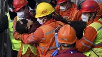 Tim penyelamat membawa seorang penambang yang terjebak di tambang ke ambulans di Kota Qixia di Provinsi Shandong, Tiongkok timur, Minggu, 24 Januari 2021. (Chen Hao / Xinhua melalui AP)