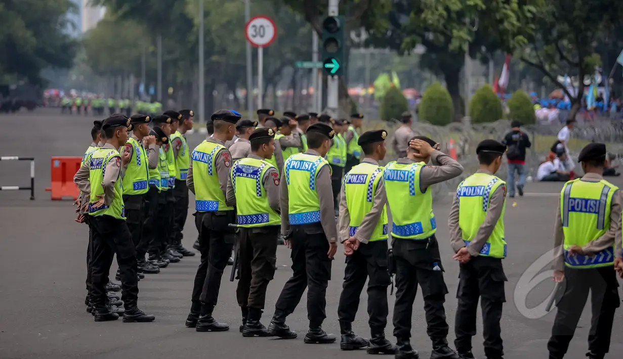 Sejumlah petugas kepolisian berjaga saat peringatan Hari Buruh (May Day) di depan Istana Merdeka, Jakarta, Jumat (1/5/2015). Penjagaan dilakukan untuk mengantisipasi aksi buruh saat perayaan hari Buruh Internasional (May Day). (Liputan6.com/Faizal Fanani)