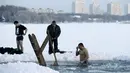 Seorang pria mandi di danau es saat prosesi perayaan Epifani Ortodoks di Minsk, Belarusia (19/1/2016). Perayaan ini diwajibkan mandi dalam kolam berisi air suci, dalam kondisi cuaca apapun. (REUTERS/Vasily Fedosenko)