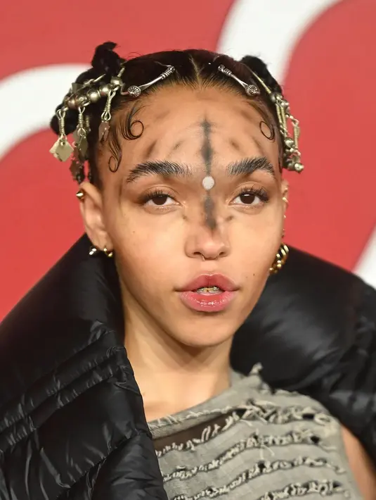 FKA Twigs menciptakan bola labirin psikedelik di wajahnya. Ia juga menghias rambutnya dengan rantai emas.