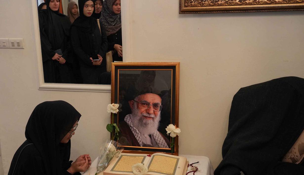 Suasana berlangsung khidmat dengan doa bersama yang dipimpin perwakilan kedutaan. Tampak dalam foto, seorang wanita berdoa di dekat potret mendiang Pemimpin Tertinggi Iran Ayatollah Ali Khamenei di kediaman duta besar Iran untuk Indonesia, Jakarta, Kamis 5 Maret 2026. (AP Photo/Tatan Syuflana)