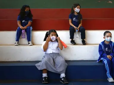 Siswa kelas satu mengenakan masker dan menjaga jarak saat kelas olahraga di sekolah teknik San Juan Bautista, Lambare, Paraguay, Rabu (17/2/2021). Beberapa SD swasta di Paraguay membuka kelas tatap muka minggu ini dengan protokol kesehatan ketat di tengah pandemi COVID-19. (AP Photo/Jorge Saenz)