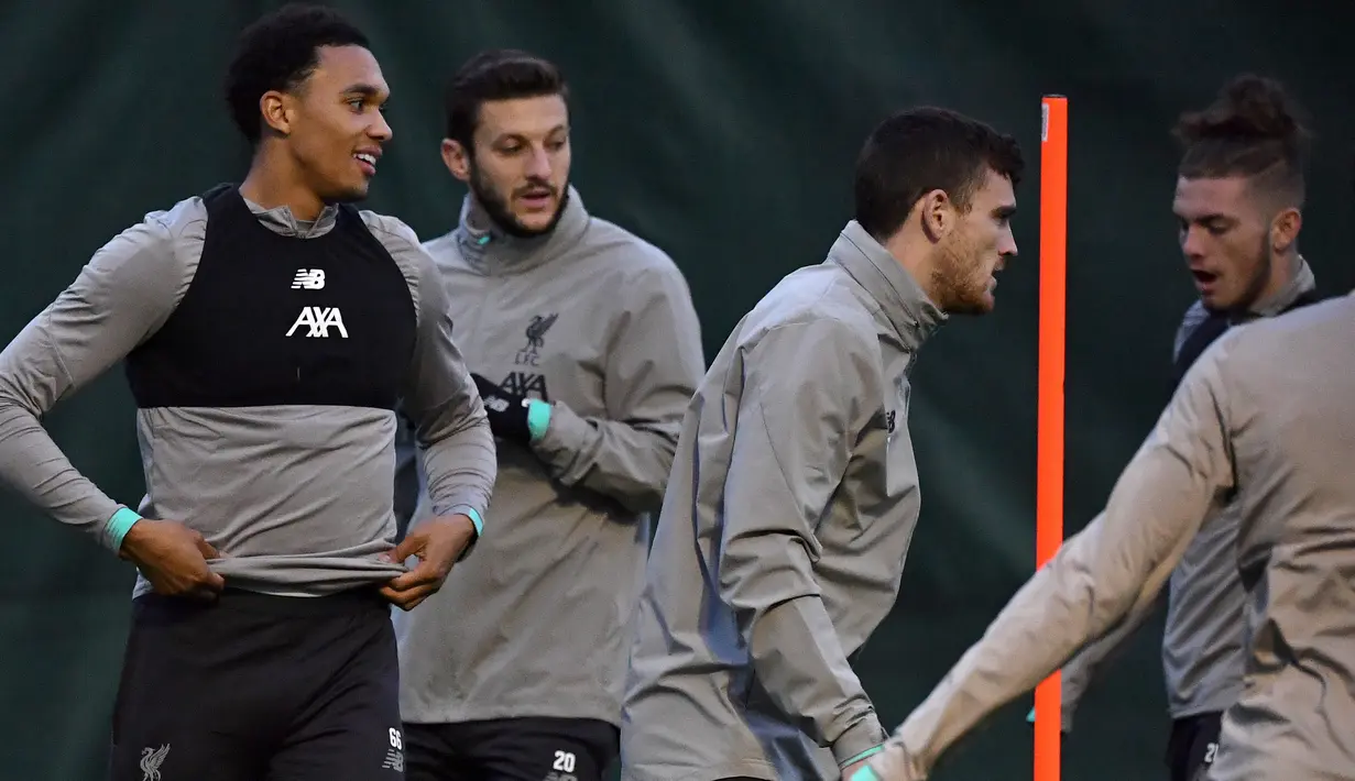 Bek Liverpool Trent Alexander-Arnold (kiri), gelandang Adam Lallana   (kedua kiri) dan bek Andrew Robertson (kedua kanan) melakukan pemanasan saat latihan di Melwood di Liverpool, Inggris (4/11/2019). (AFP Photo/Paul Ellis)