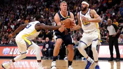 Pebasket Denver Nuggets, Mason Plumlee, berusaha melewati hadangan pebasket Golden State Warriors pada laga NBA di Pepsi Center, Denver, Sabtu (4/11/2017). Warriors menang 127-108 atas Nuggets. (AFP/Matthew Stockman)