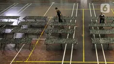 Petugas menyiapkan tempat singgah sementara bagi warga yang baru kembali ke Jakarta di GOR Cipayung, Jakarta, Selasa (18/5/2021). GOR ini jadi tempat singgah bagi mereka yang tidak memiliki tempat layak untuk isolasi mandiri sambil menunggu hasil tes swab antigen/PCR. (Liputan6.com/Herman Zakharia)