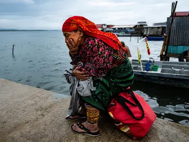 Seorang perempuan Penduduk Asli Guna menunggu di dermaga untuk pemindahannya dari pulau Carti Sugtupu ke daratan, di Guna Yala Comarca, di pantai Karibia di Panama, pada 03 Juni 2024. (MARTIN BERNETTI / AFP)