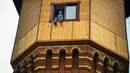 Pengusaha Rusia Alexander Lunev duduk di jendela bekas menara air, yang diubah menjadi apartemen, di kota Tomsk, Siberia pada 7 September 2020. Alexander Lunev mulai membangun kembali menara air yang dibuat pada 1895 tersebut, menjadi sebuah apartemen untuk dirinya. (Alexander NEMENOV / AFP)