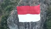 Untuk menyambut HUT RI ke-73, bendera Merah Putih raksasa dipasang di Gunung Api Purba. (Foto: Screen Capture Twitter.com, @heryfosil)