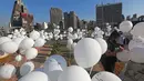 Seorang wanita menulis nama korban ledakan pelabuhan 4 Agustus pada sejumlah balon dalam upacara untuk memperingati peristiwa tersebut di Beirut, Lebanon, 4 Oktober 2020. Dua ledakan yang mengguncang Pelabuhan Beirut menghancurkan sebagian kota dan menewaskan sekitar 190 orang. (Xinhua/Bilal Jawich)