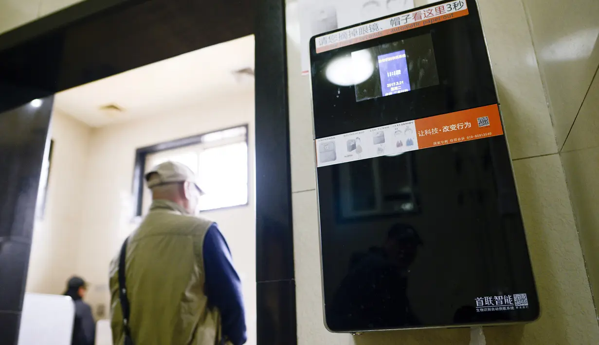 Sebuah dispenser tisu dengan kamera yang mampu mengenali wajah terpasang di toilet umum Temple of Heaven, Beijing, China, Selasa (21/3). Alat itu dipasang untuk memerangi para pencuri tisu toilet yang menjadi masalah serius di Beijing. (WANG Zhao/AFP)
