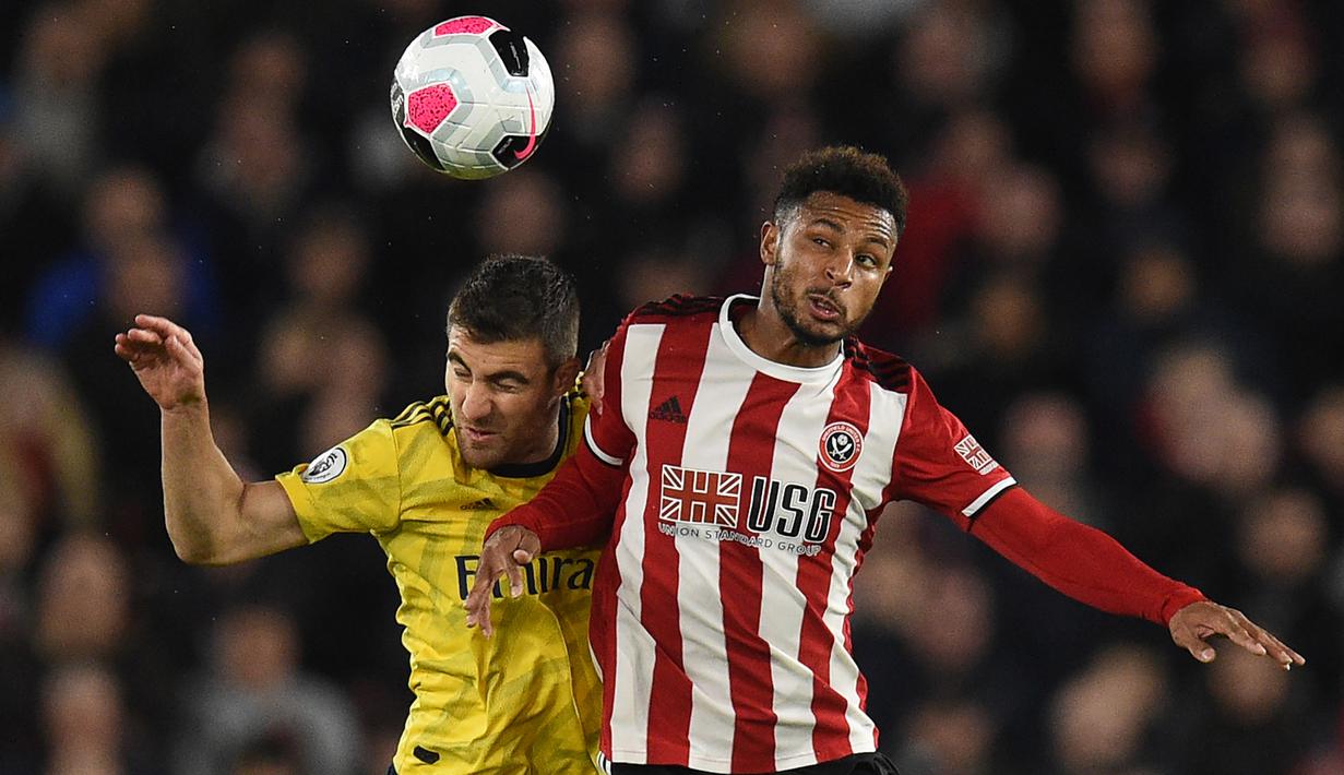 Striker Sheffield United, Lys Mousset, duel udara dengan bek Arsenal, Sokratis Papastathopoulos, pada laga Premier League di Stadion Bramall Lane, Sheffield, Senin (21/10). Sheffield menang 1-0 atas Arsenal. (AFP/Oli Scarff)