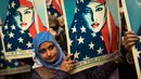 Seorang wanita membawa poster saat reli menentang kebijakan travel ban tujuh negara mayoritas Muslim yang dikeluarkan oleh Presiden Trump di New York Times Square, AS, Minggu (19/2). (AP/Andres Kudacki)