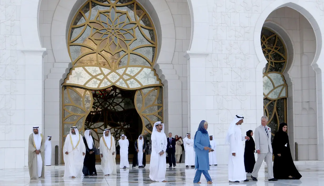 Pangeran Charles yang berpakaian formal, bersama Putri Camilla yang mengenakan pakaian seperti gamis panjang, lengkap dengan penutup rambut saat mengunjungi Masjid Syekh Zayed di Abu Dhabi, Uni Emirat Arab, Sabtu (5/11). (AFP/Karim Sahib)